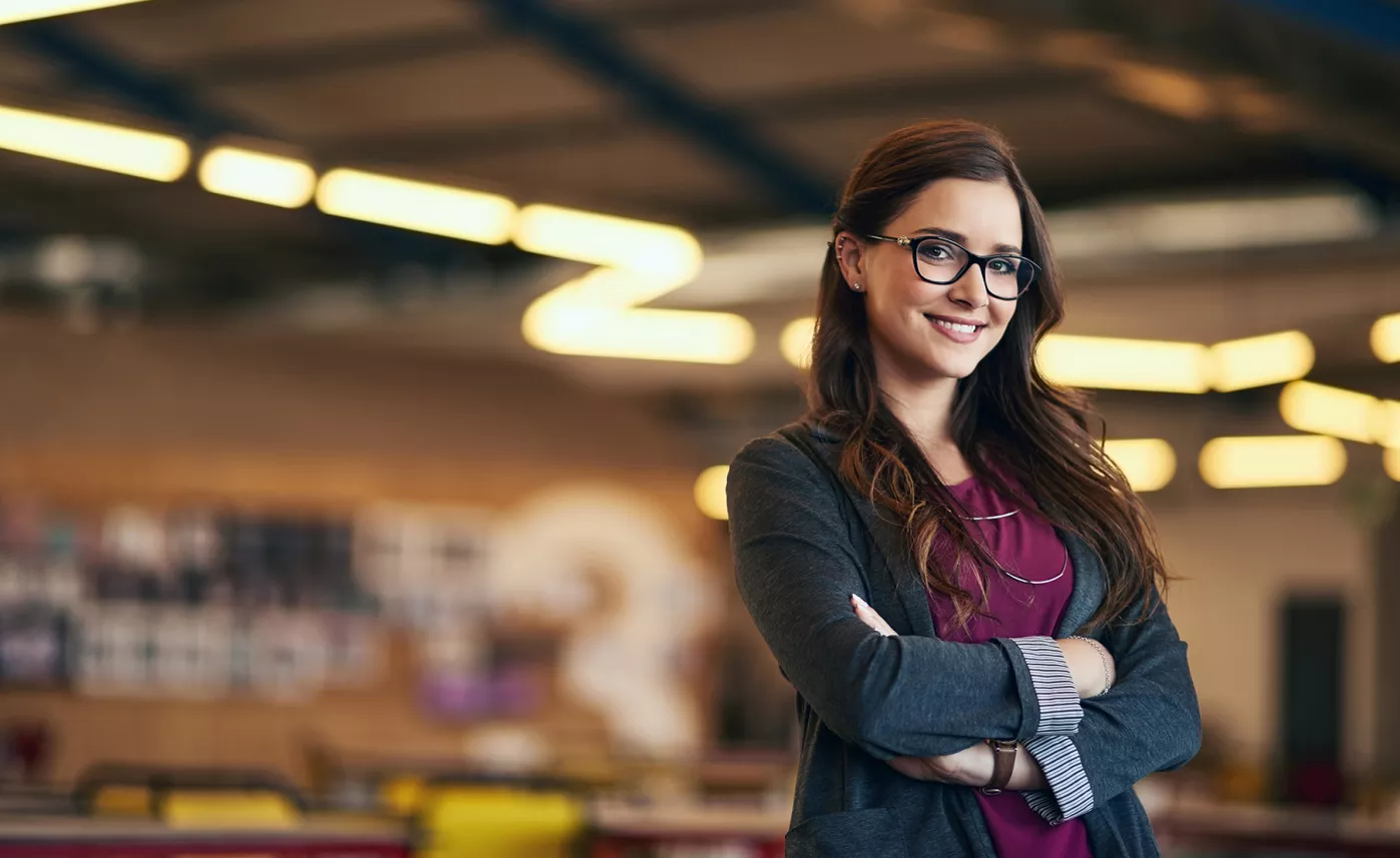  A young professional smiles in a trendy office building.
