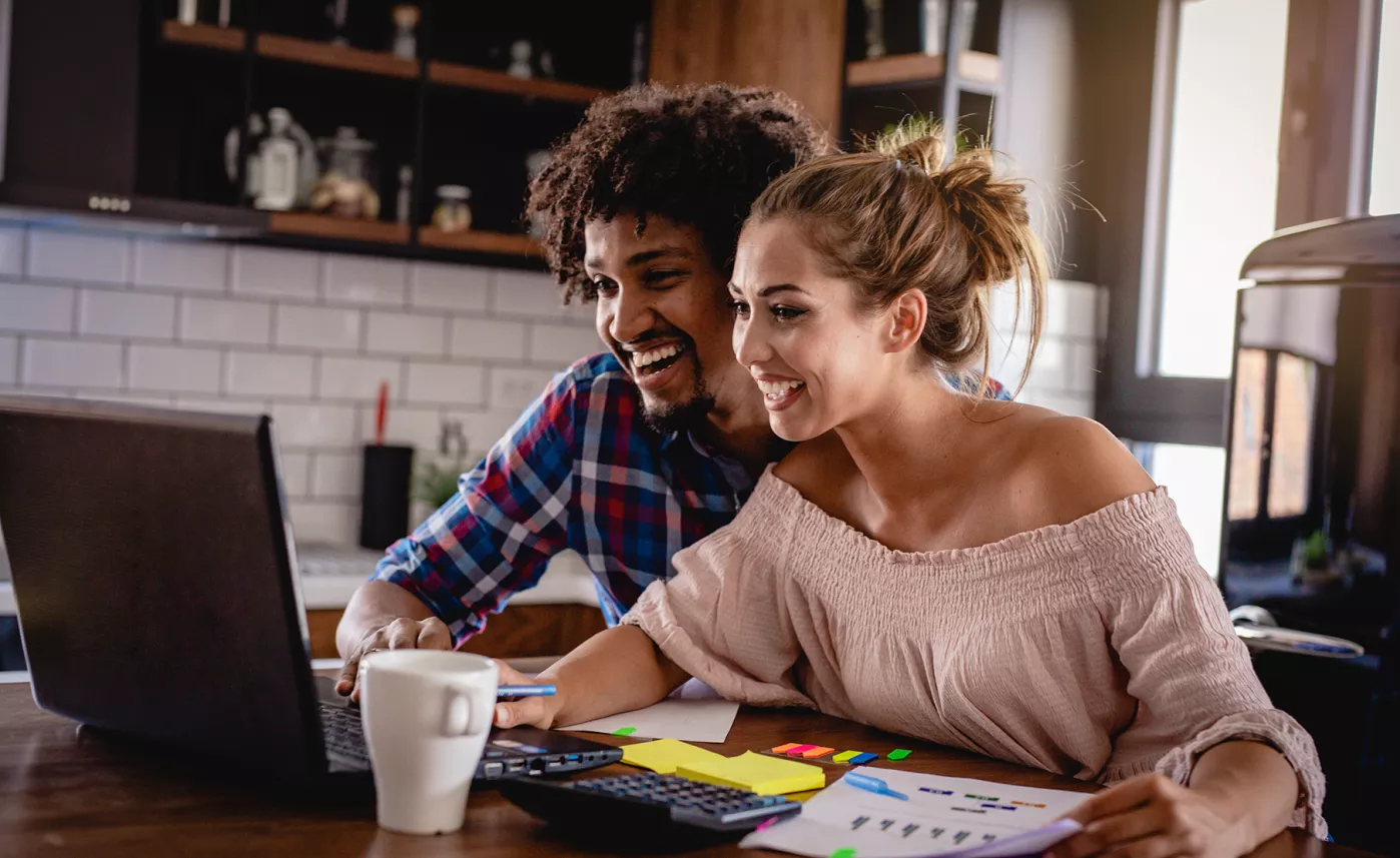  A young couple reviews their estate strategy together at home on a laptop.
