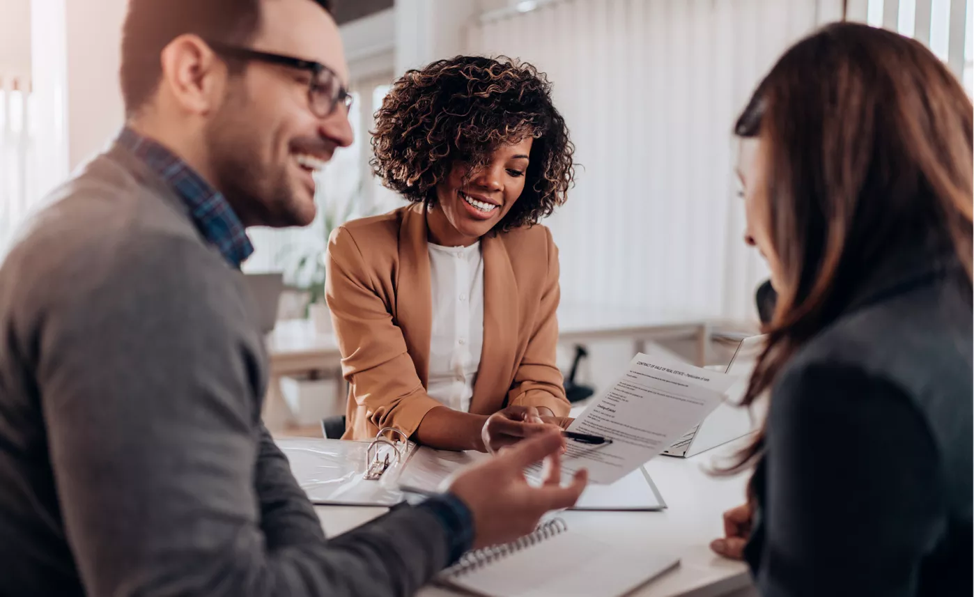  Un conseiller en investissement présente un plan de placement à un jeune couple.
