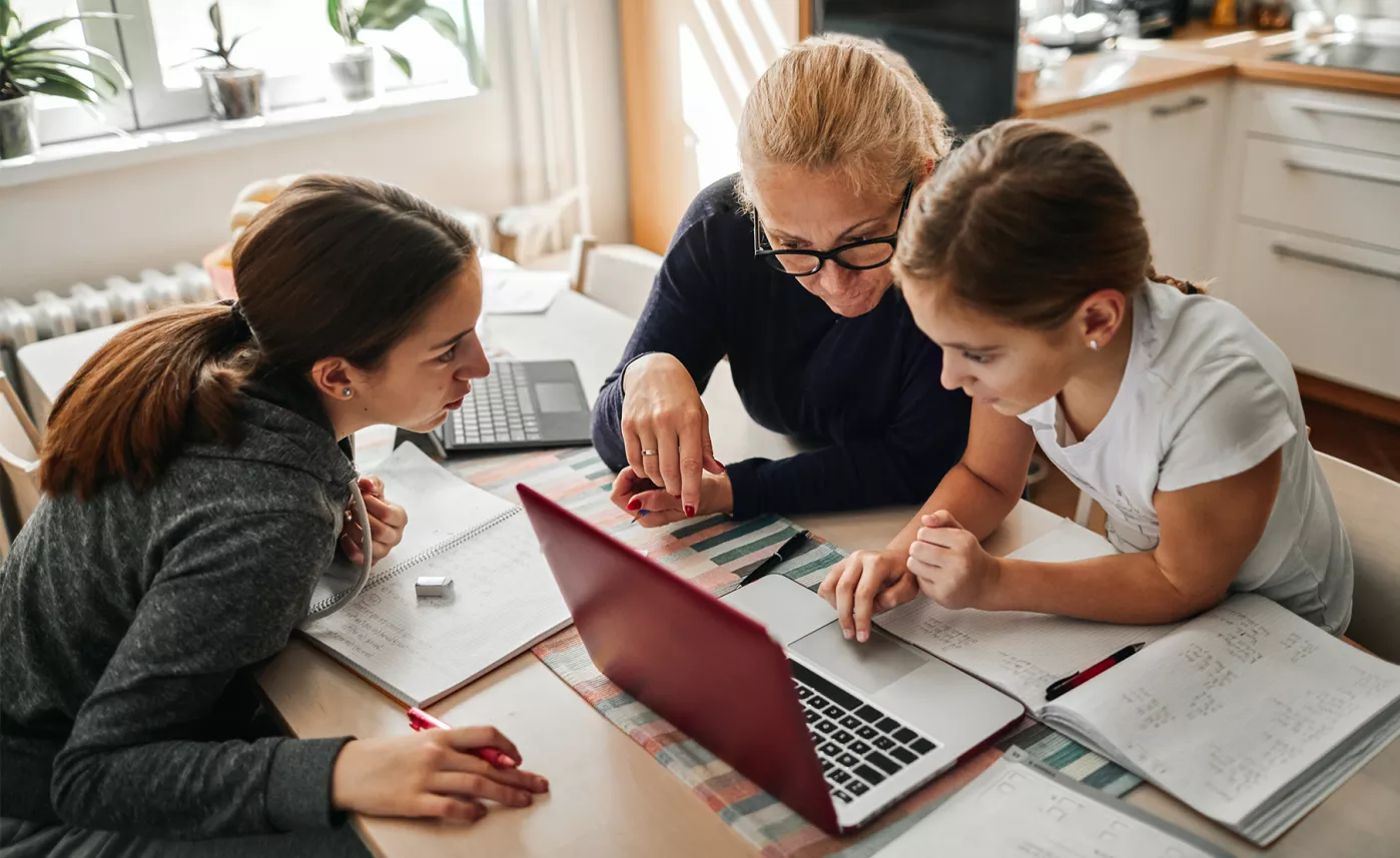  Une grand-mère aide sa petite-fille à faire ses devoirs à la table de cuisine.
