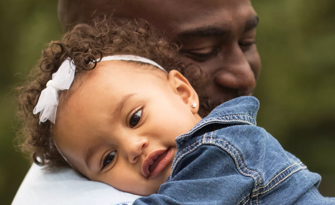  Un nouveau grand-parent tient sa petite-fille en bas âge.
