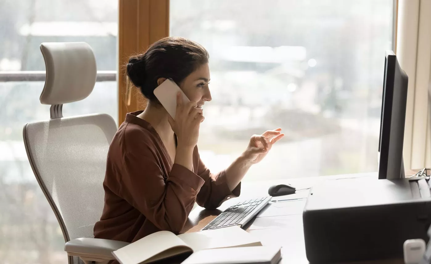  Lady sitting at her desk on her phone
