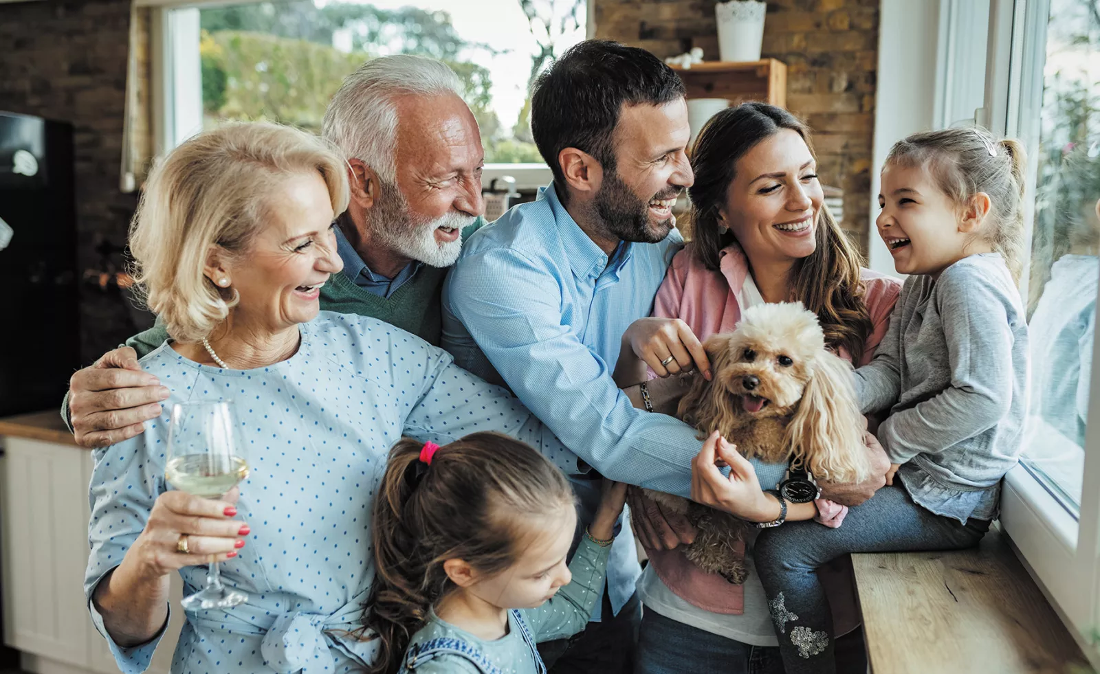  Une famille multigénérationnelle avec leur chien, riant ensemble.
