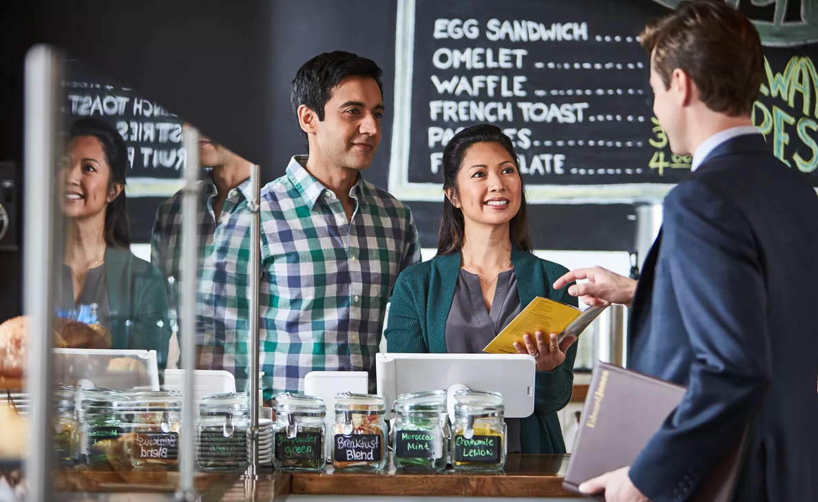  Un représentant Edward Jones visite deux propriétaires d’un café dans leur commerce.
