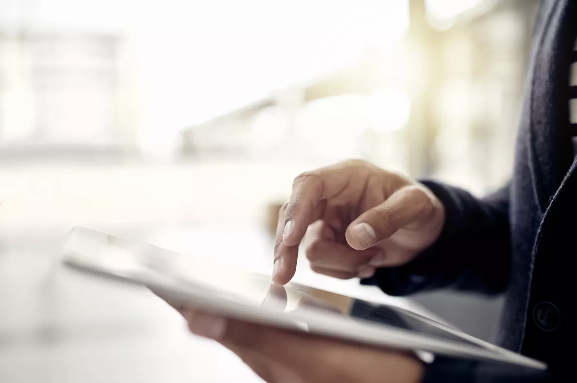  A man reads from a tablet in an office building.
