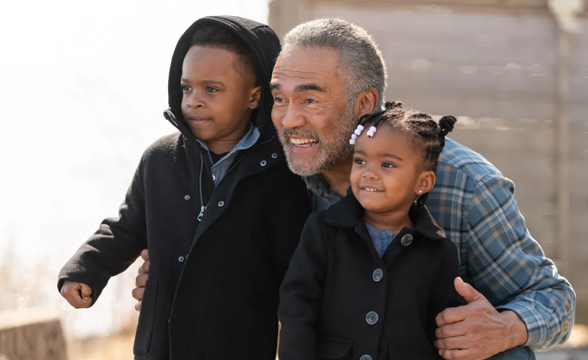  A grandfather and his two young grandchildren pose for a photograph.
