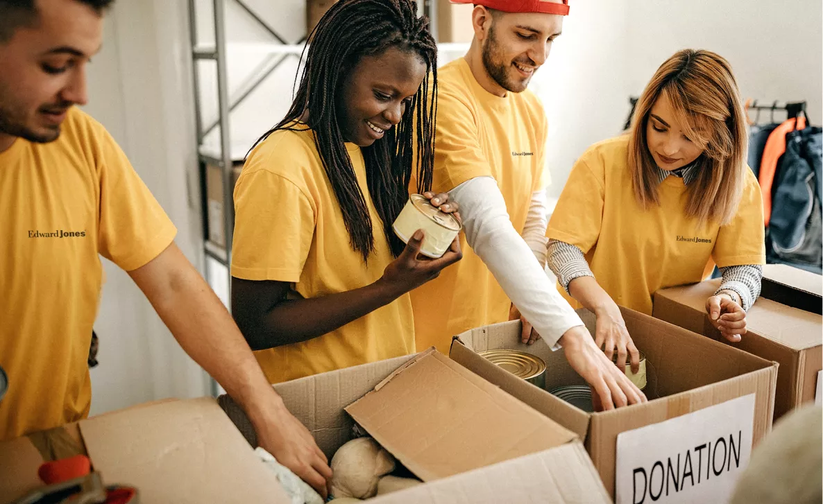  Une équipe de bénévoles d’Edward Jones travaille sur des boîtesd’aliments donnés
