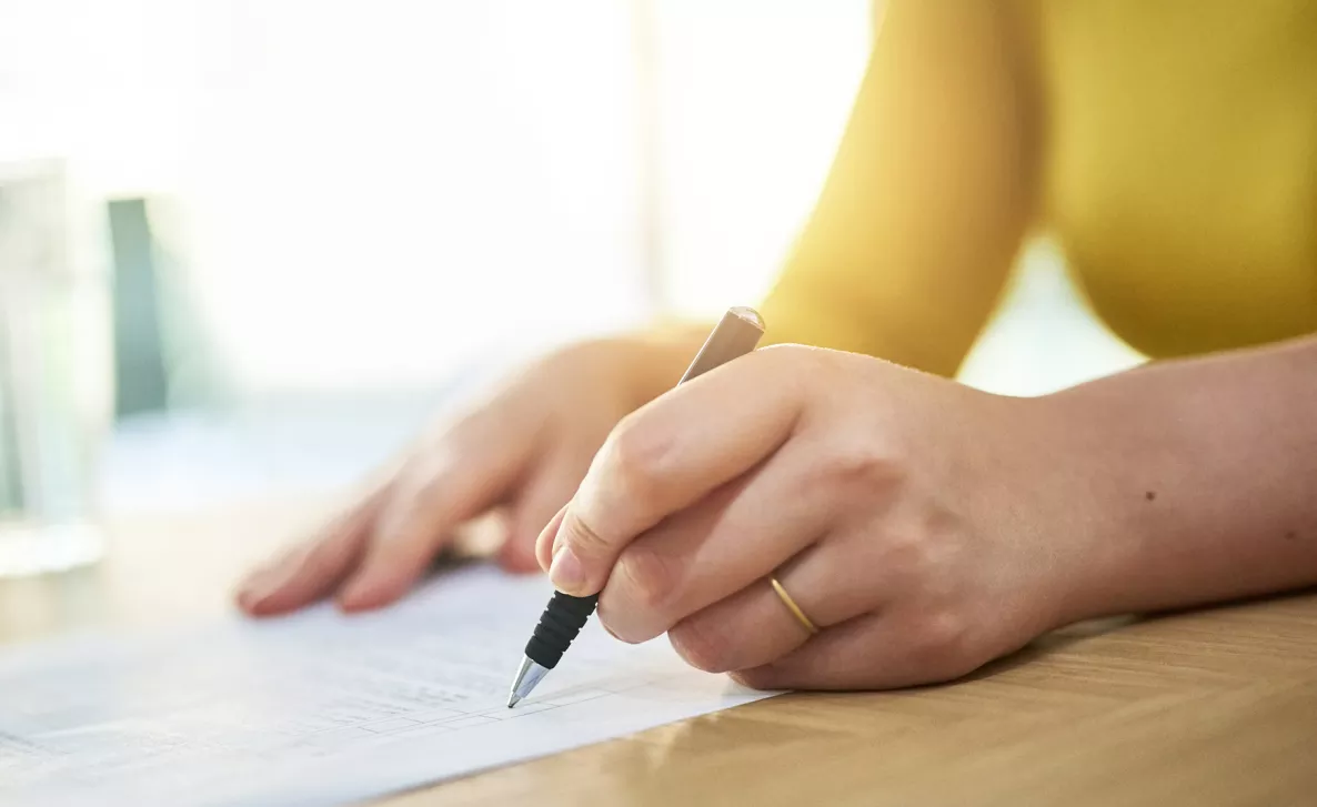  Une femme coche les tâches d’une liste sur une feuille de papier.
