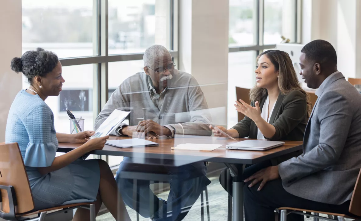  An Edward Jones financial advisor discusses a plan with a family of clients, including an elderly client.
