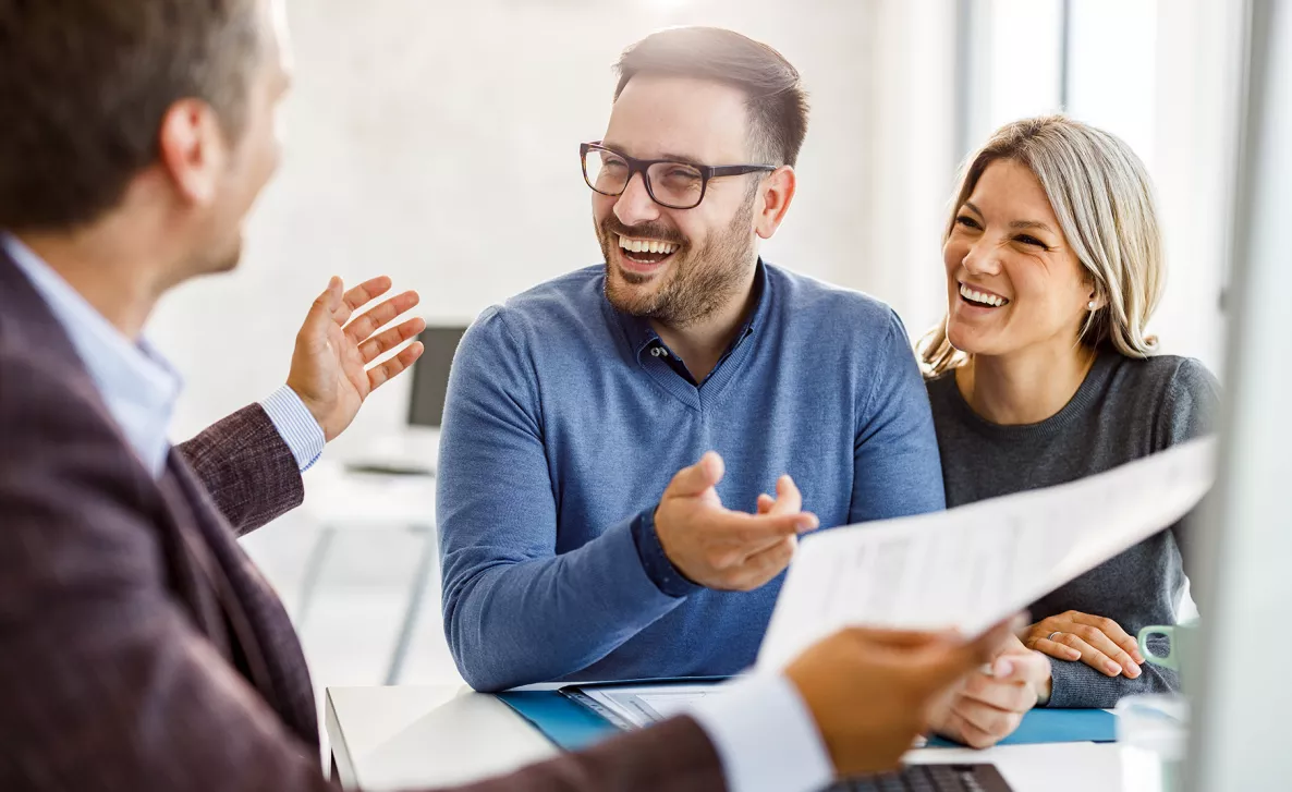  A couple laughing with their financial advisor.
