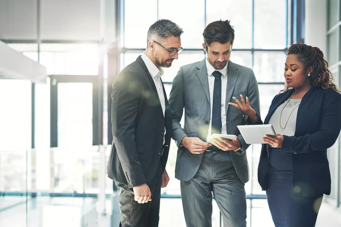  Three Edward Jones associates discuss finances in a modern office building.
