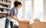 A woman unboxes her things in a new home after a recent move.