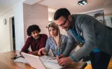 An Edward Jones financial advisor helps two client with their financial portfolio.