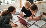 A grandmother helps her young granddaughter with her homework at the kitchen table.