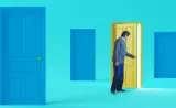 A person in a room of blue doors, walking through a yellow door.