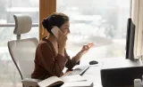 Lady sitting at her desk on her phone