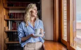  Woman staring out the window with the cup in her hand